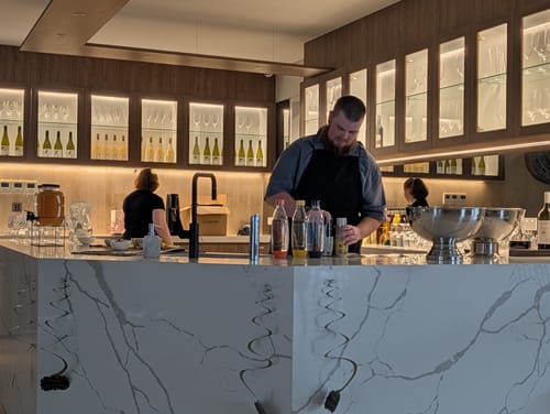 Customer preparing cocktails with the Ultimate Entertainers Pack mixers at a modern bar for a party.