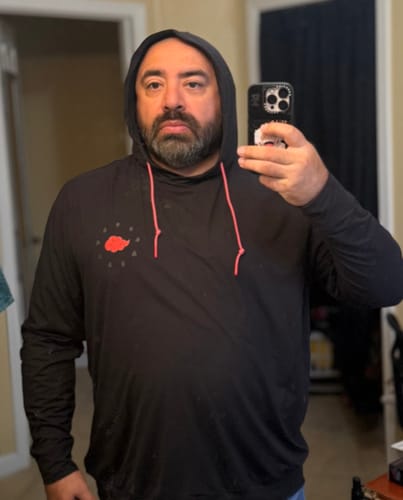 Customer wearing the black 'Akatsuki' Performance Hoodie with the hood up in a mirror selfie.