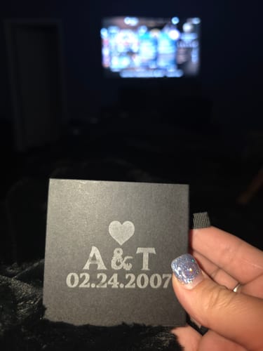 Reviewer holding their small black customized box, showing the engraved text 'A & T' and '02.24.2007'.