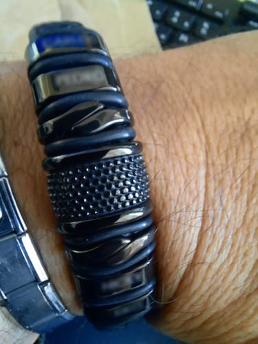 Close-up of a customer's personalized black bracelet on their wrist, showing an engraved bead.