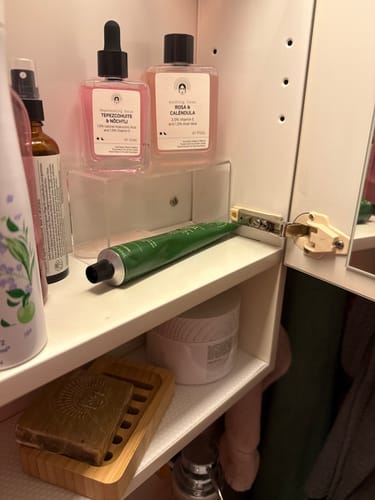 Reviewer's Barrier Protection Routine products organized on a shelf in a white medicine cabinet.
