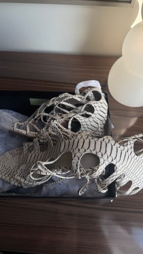 Customer's python-print Snake Heels with a strappy lace-up design, displayed in their original box.