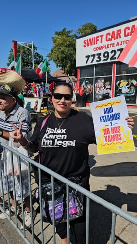 Reviewer wearing the black Relax Karen I'm Legal OG T-Shirt at an outdoor parade while holding a sign.