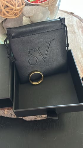 Cliente mostrando el Anillo Minimal Oro dentro de su caja negra y su funda con el logo SV.