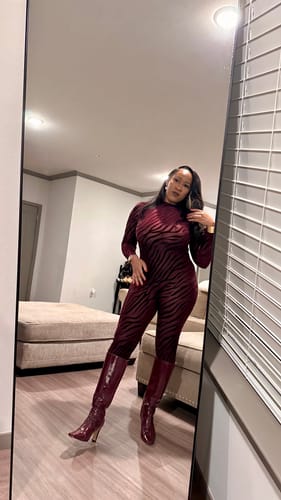 Customer's full-length mirror selfie showing the fit of the red patterned Burnout Closed Toe Jumpsuit.