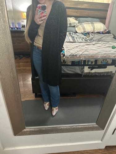 Customer wearing the long black Velvet Crush Duster over a tan top and jeans in a full-length mirror selfie.