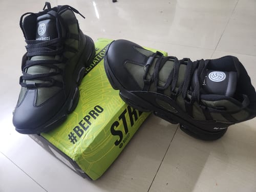 Reviewer's new black and green Bacca Bucci Dominator sneakers displayed on their shoebox.