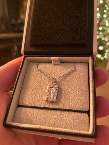 Customer's Imperfectly Perfect Pendant with a textured front, displayed in its open presentation box.