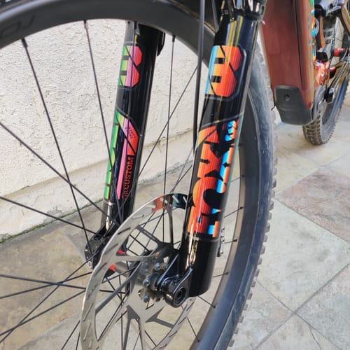Customer's colorful Custom Fox 38 Decal applied to the black suspension fork of a mountain bike.