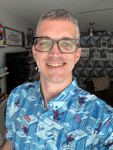 Reviewer smiling while wearing the blue "Spider-Man Is Coming to Town" KUNUFLEX Short Sleeve Shirt.