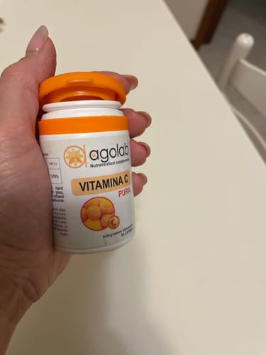 Recensore che tiene in mano il flacone bianco e arancione di Vitamina C Pura.