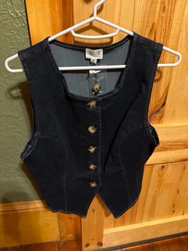 Customer's dark Downtown Denim Vest with button-front detail, shown on a white hanger.