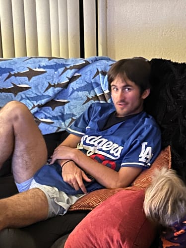 Customer's photo of the recipient of the 'To My Son' gift set, a person in a jersey relaxing on a couch.