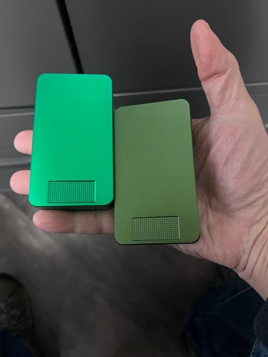 Reviewer holding a green and an olive green Nano Case side-by-side in their hand.