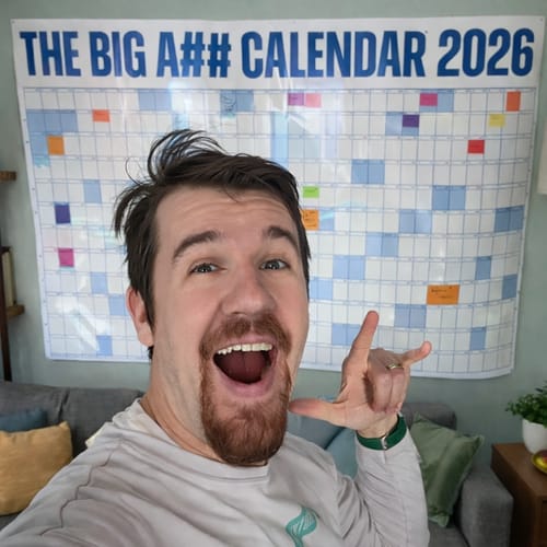 Customer smiling in front of the large BIG A## CALENDAR 2026, mounted on a wall with colorful planning labels.