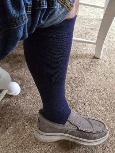 Customer wearing dark Performance Eucalyptus Compression Socks with casual grey shoes indoors.
