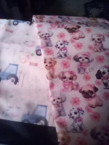 Reviewer's End of Bolt Mystery Fabric showing two children's prints: one with blue tractors and another with dogs and pink bows.