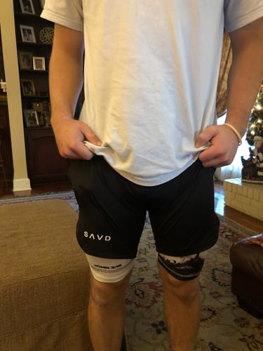 Reviewer wearing the black John 3:16 performance shorts over a white compression layer with visible scripture text.