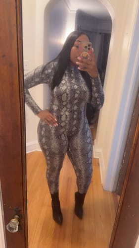 Reviewer shows the form-fitting style of the snakeskin-print Naked Print Jumpsuit in a selfie.