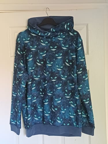 Customer's finished hoodie made from the Galaxy Cats fabric, with a dark blue cat print and solid blue cuffs and hood lining.