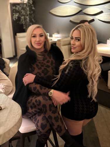 Customer wearing the Naked Print Tights as a full bodycon outfit while seated in a restaurant with a friend.