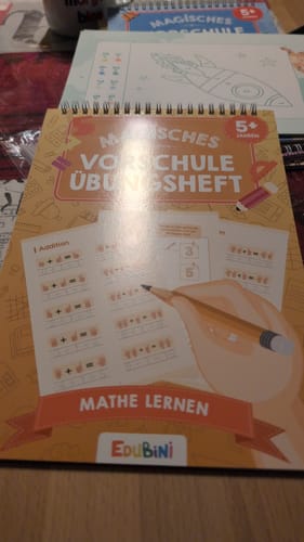 Kundenbild des Edubini Übungshefts 'Mathe Lernen', das auf einem Tisch liegt.