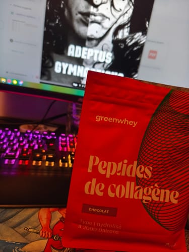 Client montrant le sachet rouge de Peptides de Collagène au chocolat devant son clavier d'ordinateur.