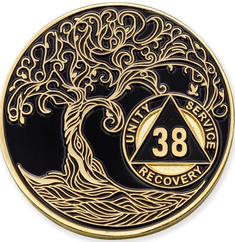 Customer's close-up of the black and gold 38 Year AA Recovery Medallion, showing the intricate Tree of Life design.