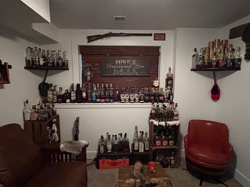 Customer's personalized Basement Bar Sign hanging in a well-stocked home bar room.
