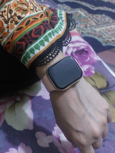 Customer wearing the Primo Smartwatch with a gold case and light pink band on their wrist.