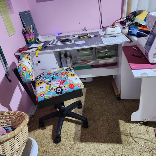 Reviewer's Arrow Hydraulic Sewing Chair with a colorful patterned fabric in a craft room.