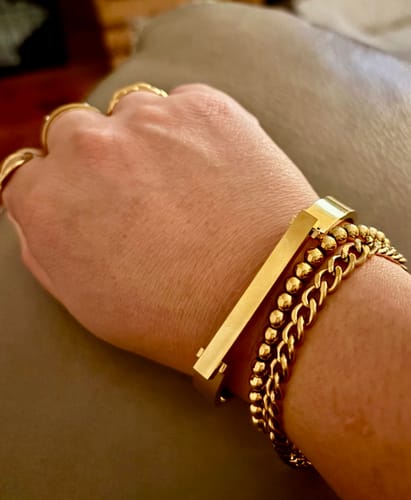 Customer's wrist showing the stacked Havana Shore Bracelet bundle, featuring three distinct gold-colored bracelets.