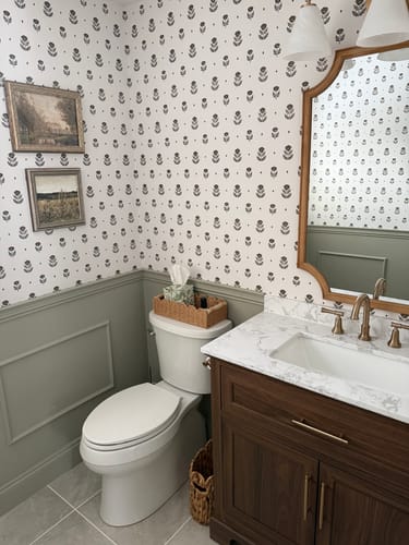 Reviewer's Delaney Wallpaper installed in a remodeled bathroom above sage green wainscoting.