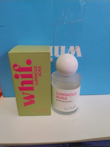 Customer's Luminous Aura perfume bottle with a white cap next to its bright green box.