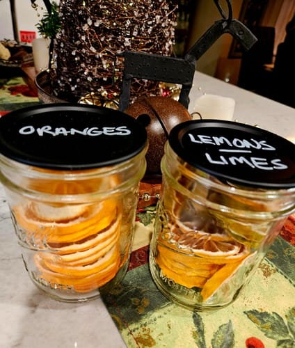 Customer shows two mason jars of dried citrus fruits, sealed using the Mason Genie Vacuum Sealer Kit.