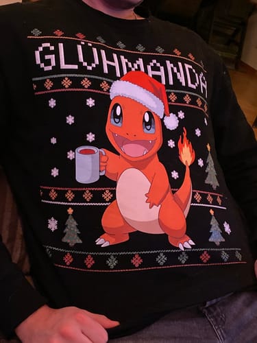 Ein Kunde trägt den schwarzen GLÜHWEIN GLÜHMANDA Pullover mit dem weihnachtlichen Cartoon-Motiv.