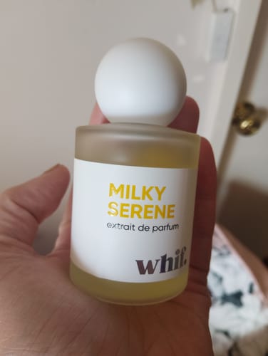 Reviewer holding the frosted glass bottle of Milky Serene perfume in their palm.