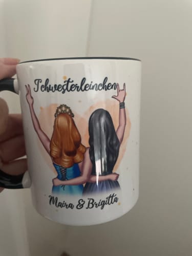 Ein Rezensent hält eine personalisierte Tasse mit einer Zeichnung von zwei Freundinnen und der Aufschrift 'Schwesterleinchen'.