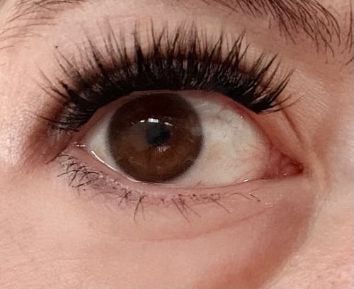 Close-up of a customer's eye with long, full lashes and a dark lash line from the Night Line® Sealer.