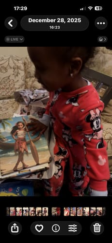 A reviewer's child in red pajamas looking at her personalized 'The Island Princess' portrait.