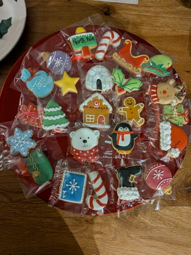 Customer's individually wrapped Christmas biscuits on a red tray. The colorful biscuits feature various festive designs and shapes.