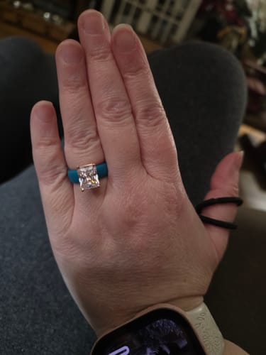 Customer wearing the Silicone Ring, showing the teal band and large emerald-cut CZ on their hand.