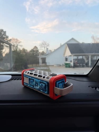 Customer's Turtlebox Wrap with a blue and white design on a speaker, shown lying on a car dashboard.