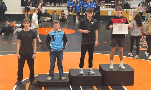 Reviewer's son on a winner's podium at a wrestling tournament wearing the dark Soldier’s Faith Performance Shorts.