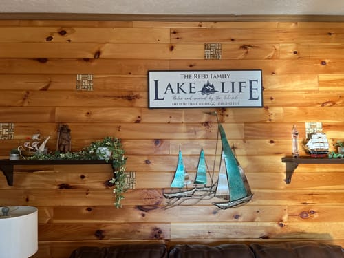 Customer's Personalized Lake Life Sign displayed on a wood-paneled wall in their lake house.