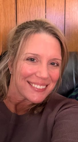 Reviewer smiling, showing smooth and radiant skin after using the Grass Fed Tallow & Honey Balm.