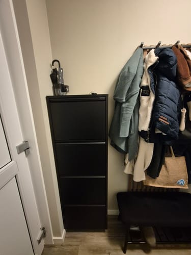 De zwarte Billy 4 schoenenkast van een recensent, geplaatst in een hal naast een kapstok.