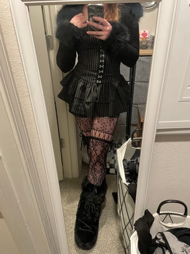 Customer wearing the Grunge Doll Stripes Flared Romper Dress, styled with a furry jacket and patterned tights.