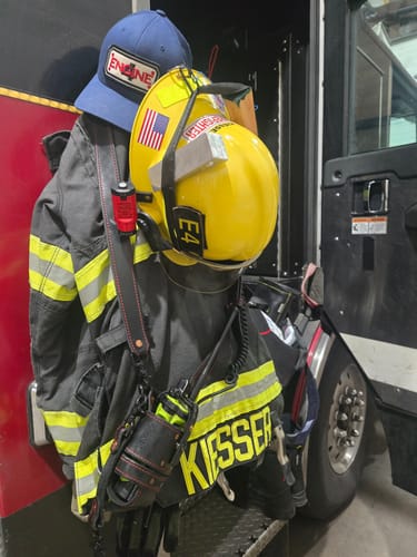 Reviewer's blue FLEX-FIT HOSE HAT hanging with their firefighter helmet and turnout gear.