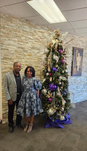 Reviewer wearing the Bunmi African Print Midi Dress with puff sleeves, standing next to a Christmas tree.
